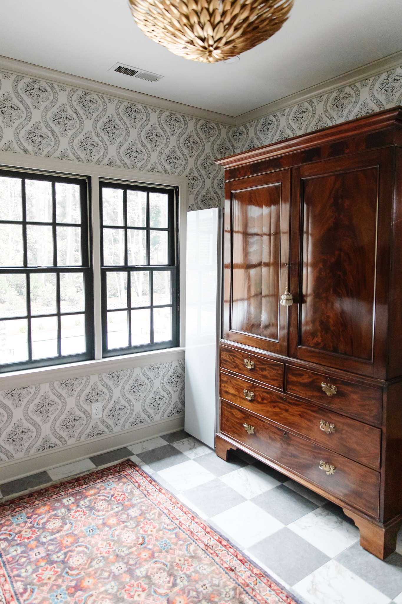 Chris Loves Julia | Laundry room with black and white wallpaper and vintage armoire