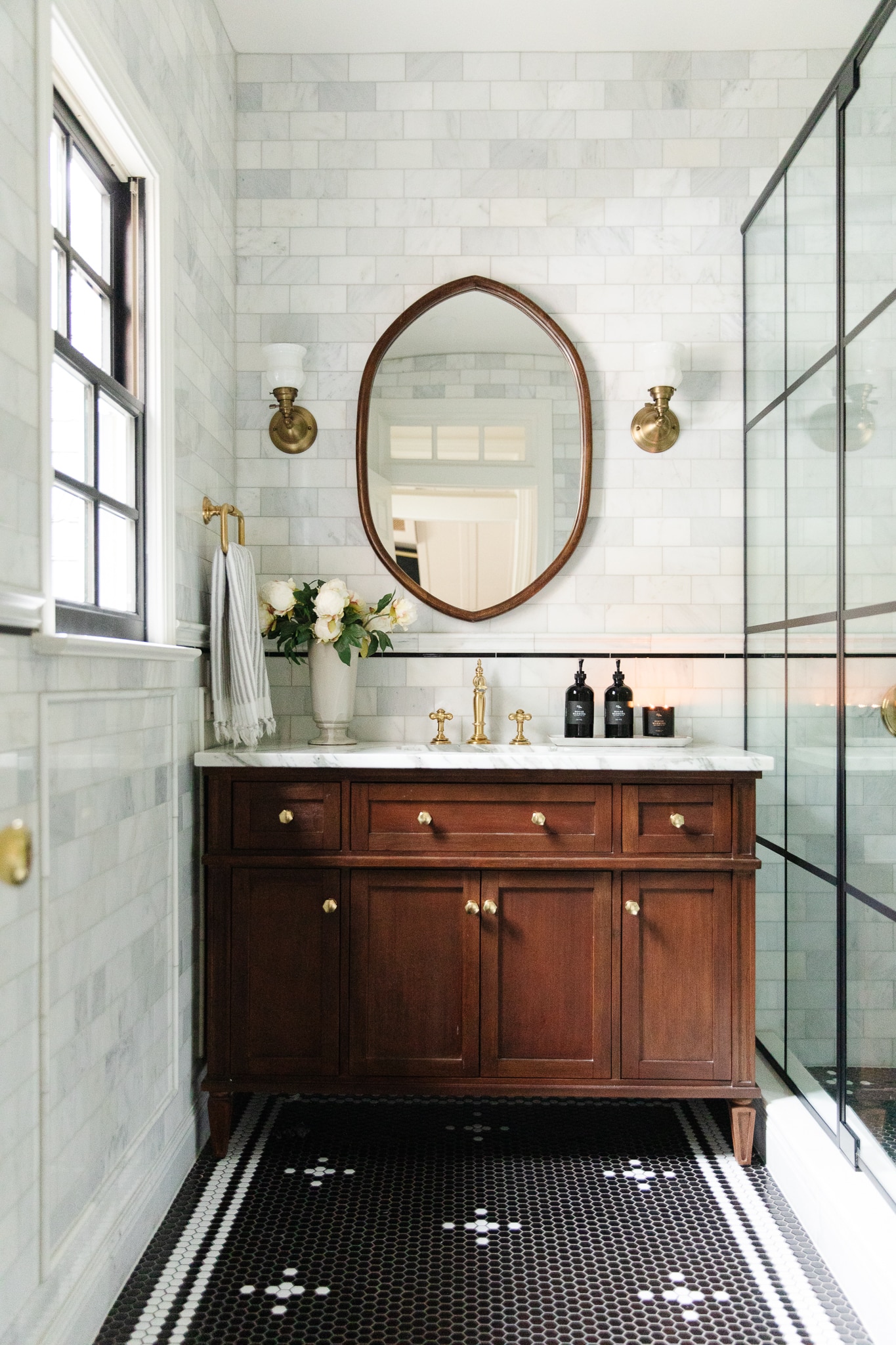 Chris Loves Julia | Greta's bathroom with beautiful wood vanity, marble counter and marble tile walls
