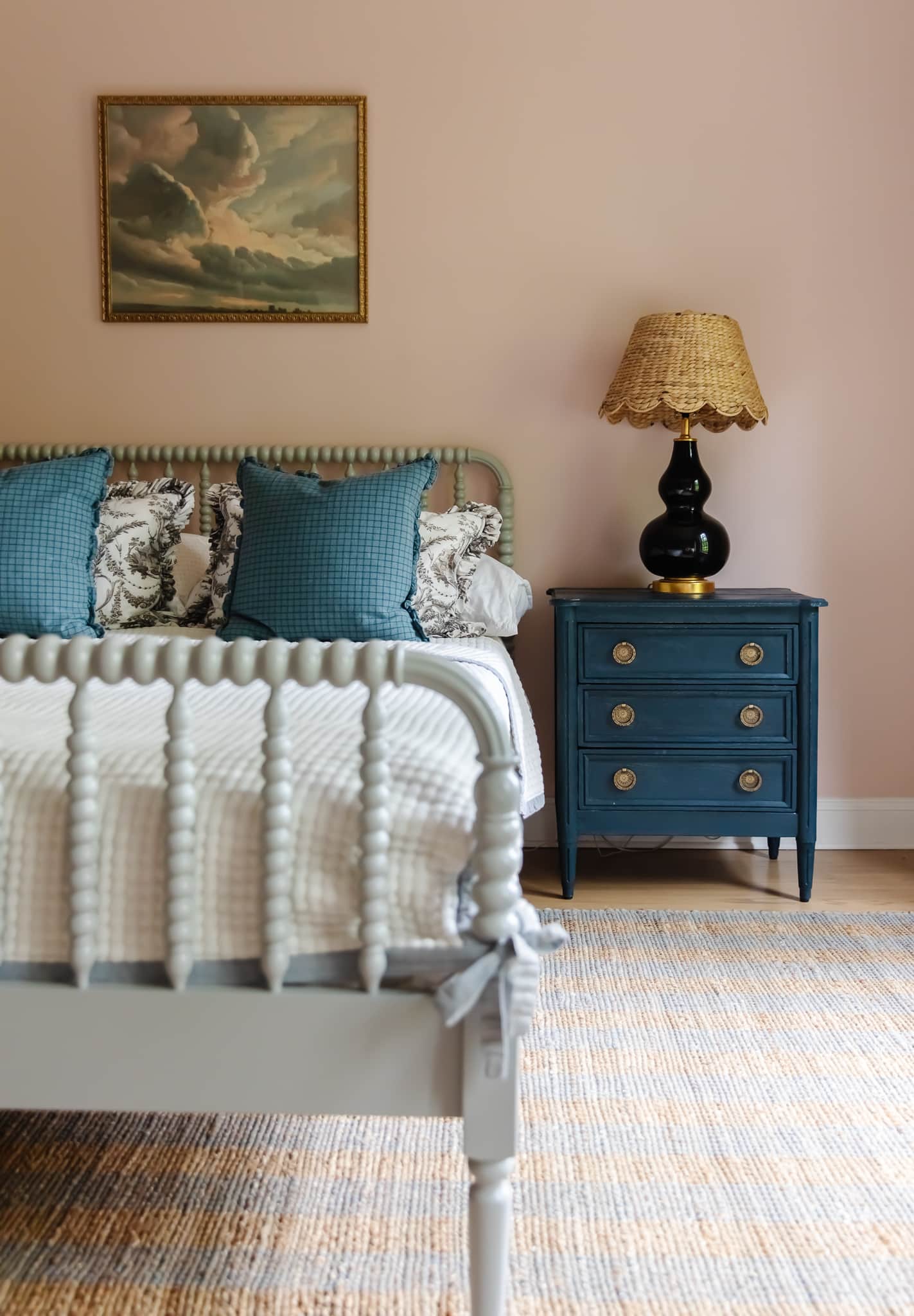 Chris Loves Julia | Greta's bedroom with pale pink paint, navy nightstand and turned wood bed.