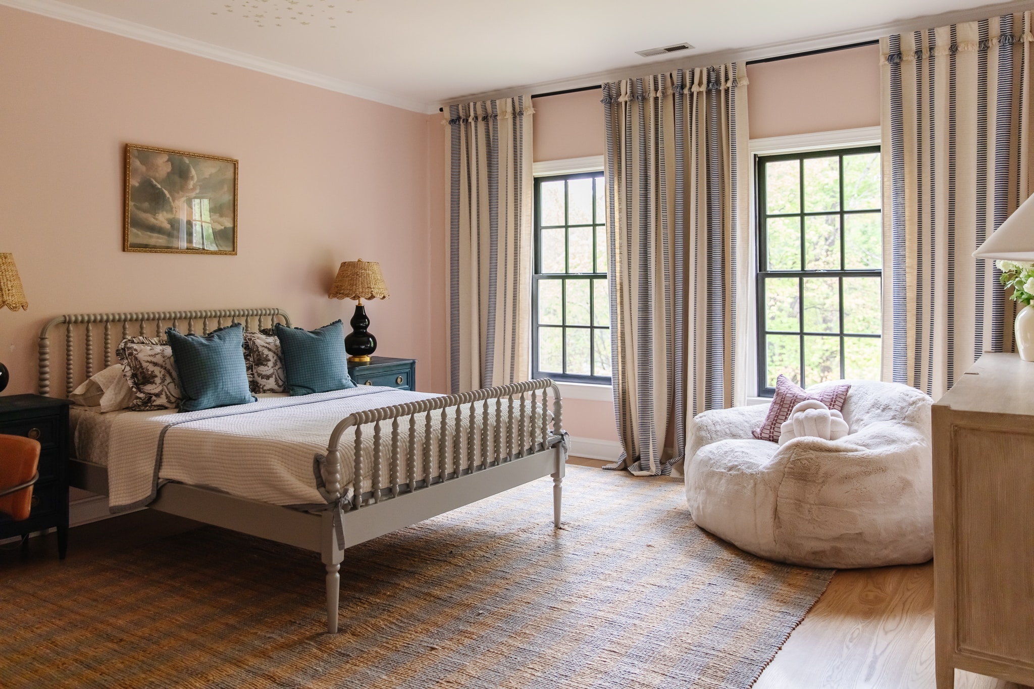 Chris Loves Julia | Greta's bedroom with pale pink paint, striped curtains and turned wood bed.