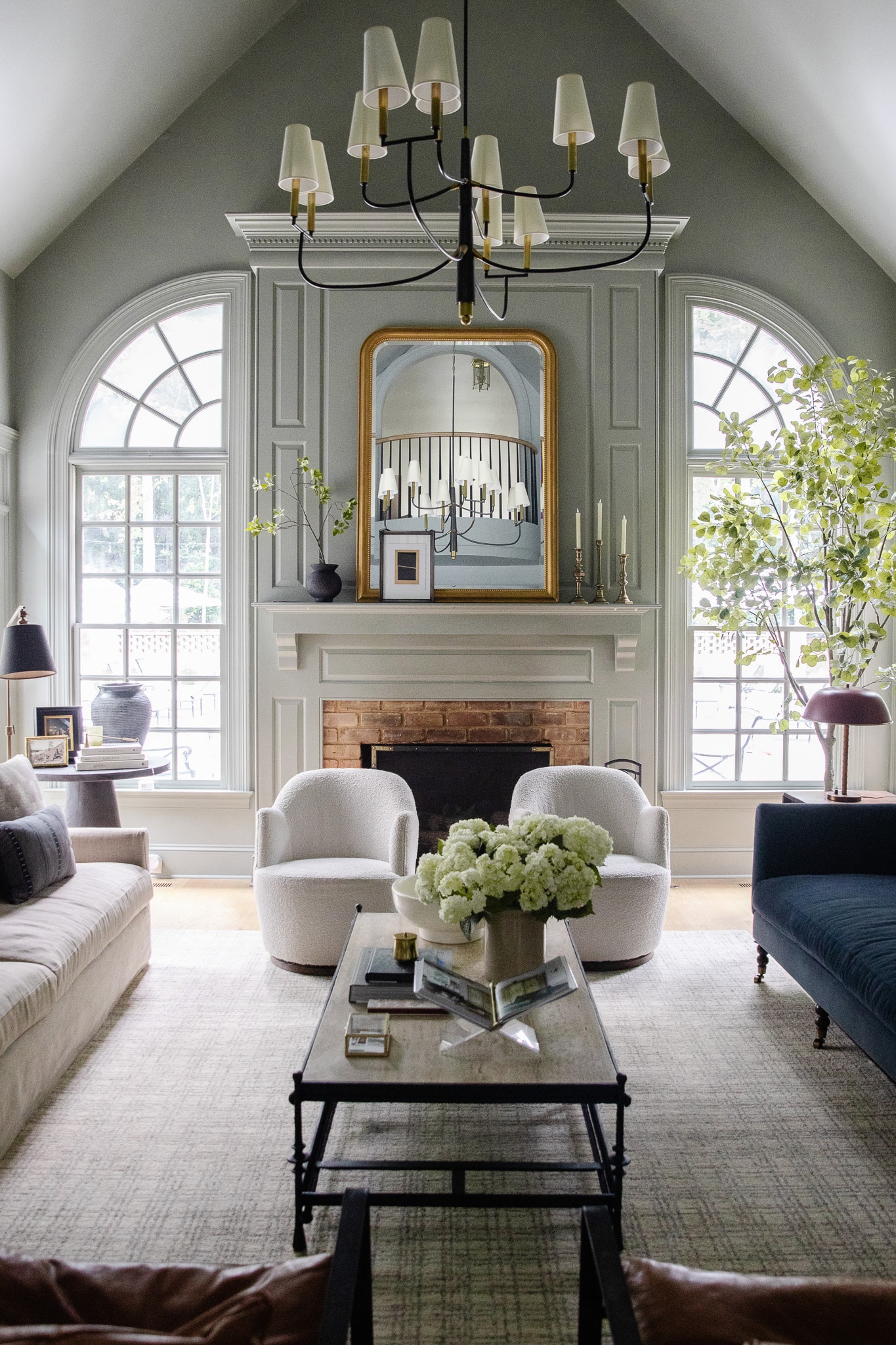 Chris Loves Julia | The living room with original white arched windows flanking the fireplace
