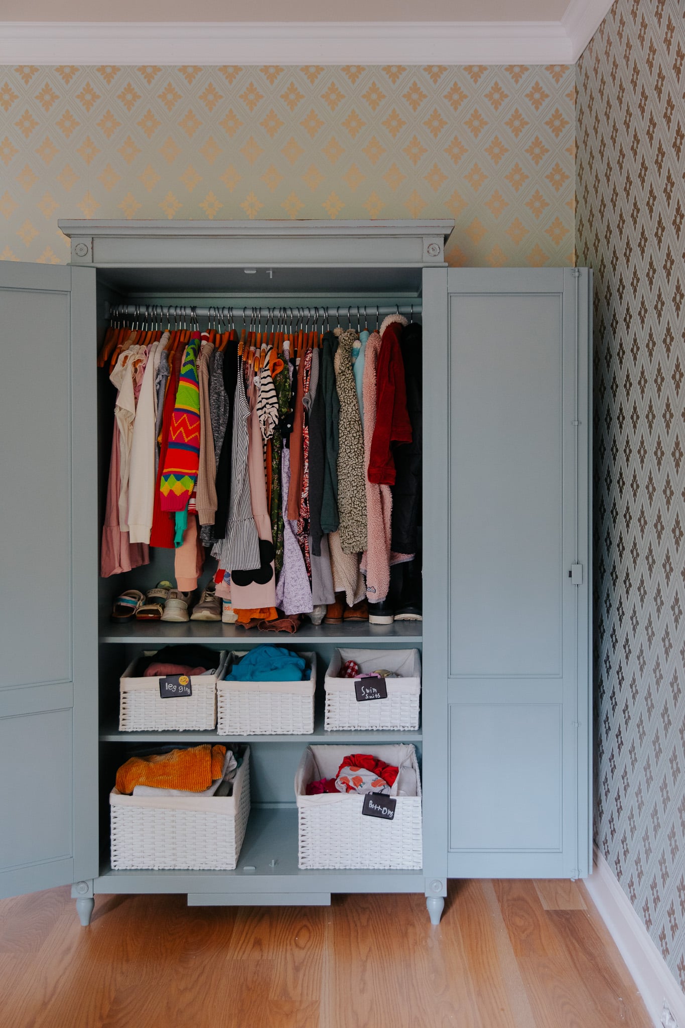 Chris Loves Julia | Blue painted armoire filled with clothes in a child's bedroom
