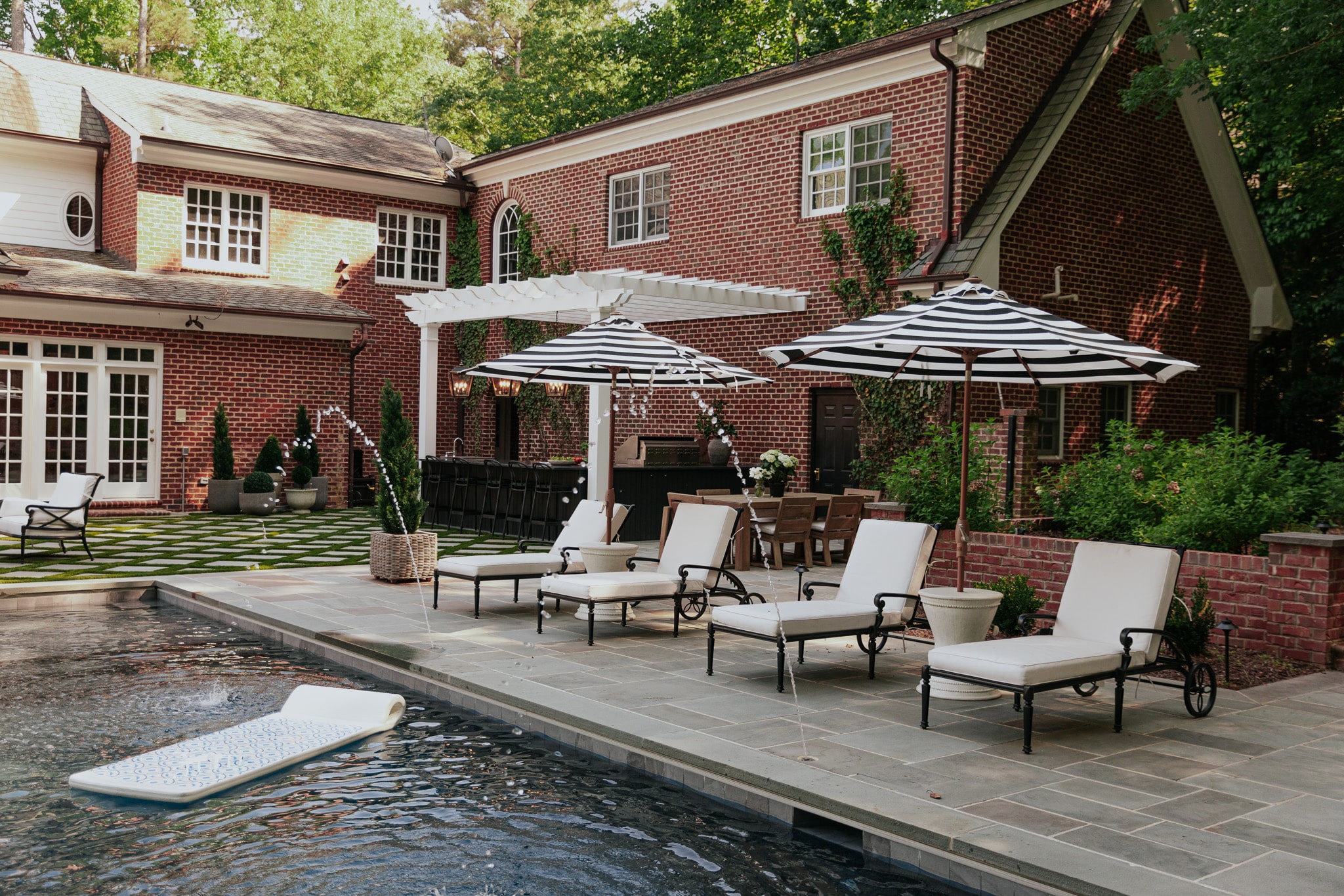 Chris Loves Julia | Modern Colonial Brick Home Backyard Exterior with White Paint Trim and Pool 