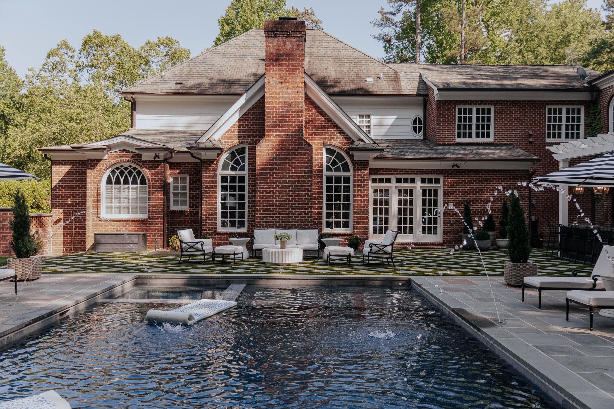 Chris Loves Julia | Modern Colonial Brick Home Backyard Exterior with White Paint Trim and Pool 